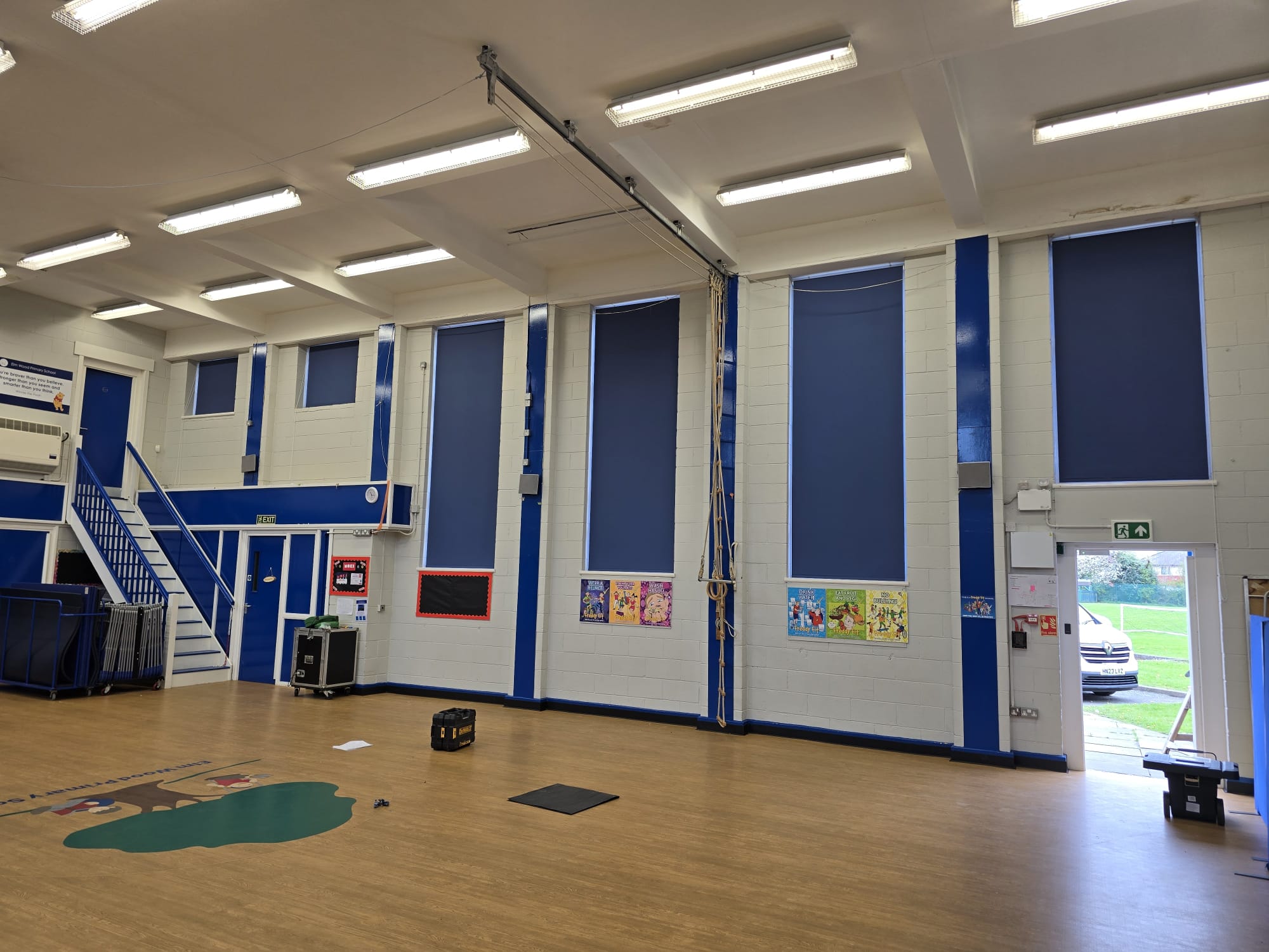 Blue blackout roller blinds in a school hall