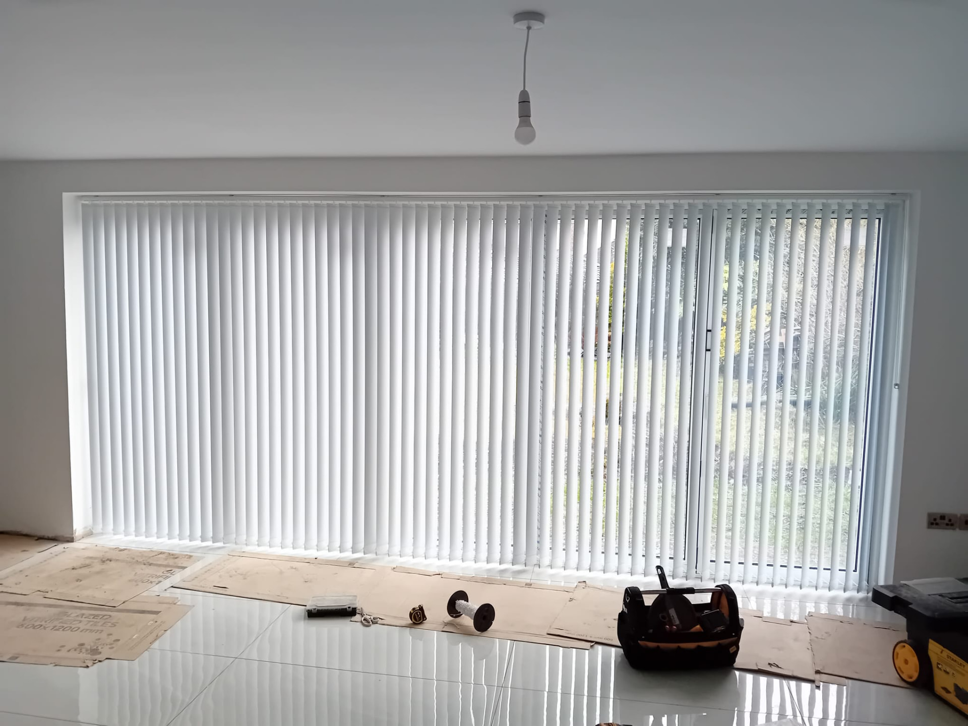 White vertical blinds fitted across wide patio doors