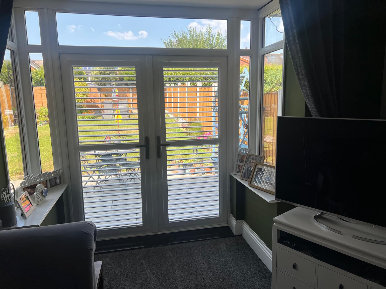 Perfect fit shutters fitted to French doors in a Manchester living room