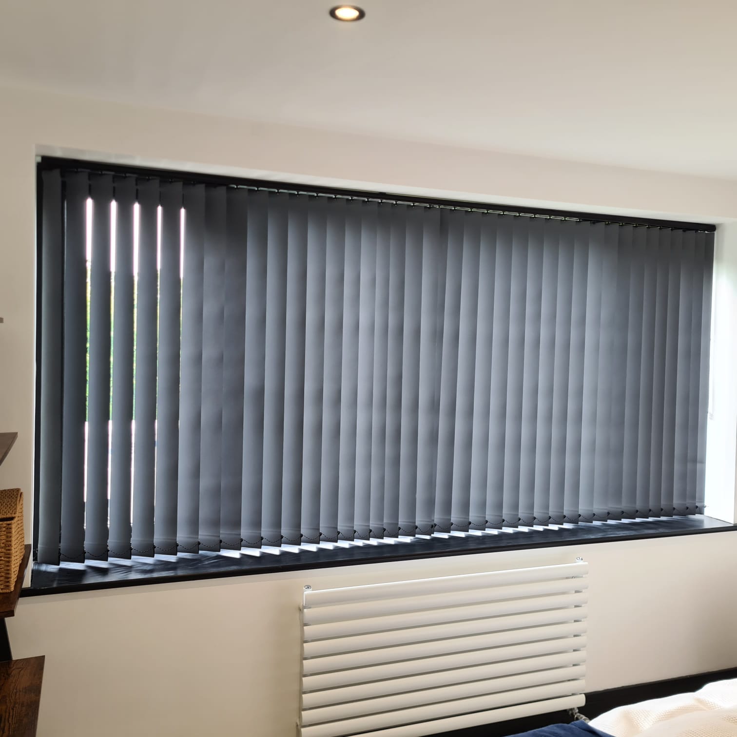 Grey vertical blinds across a large window