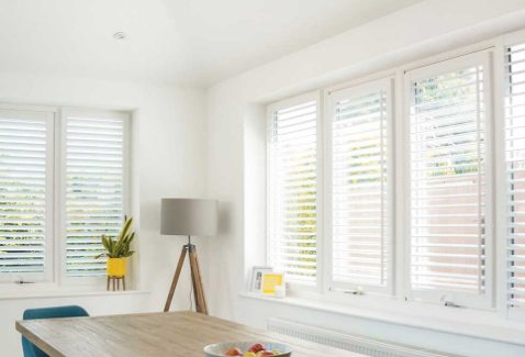 White perfect fit shutters across dining room windows