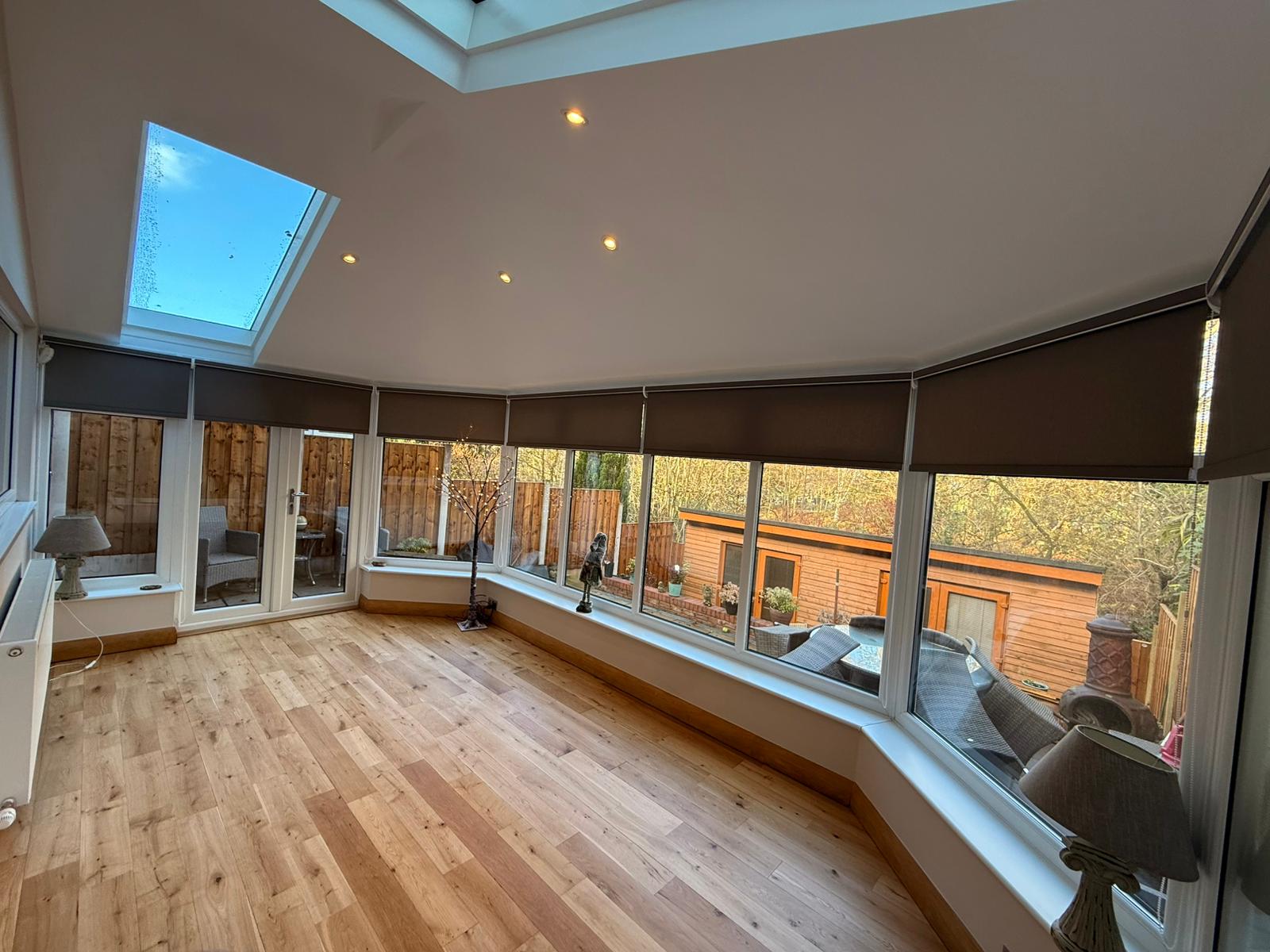 Brown blackout roller blinds around a conservatory with skylight