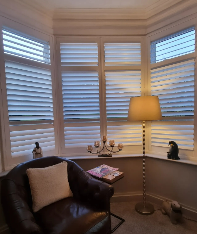 White plantation shutters in a bay window lounge