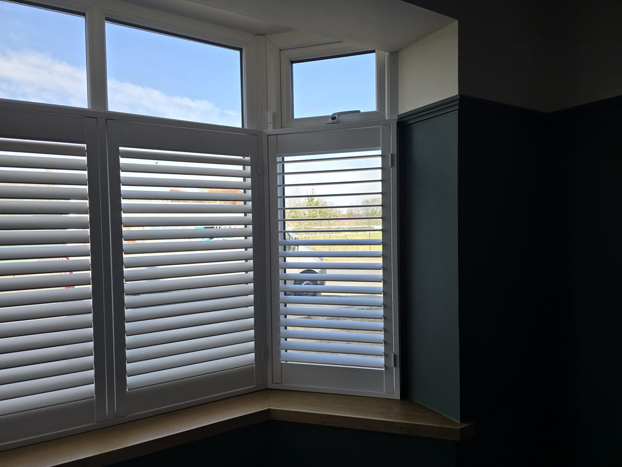 White plantation shutters in a bay window