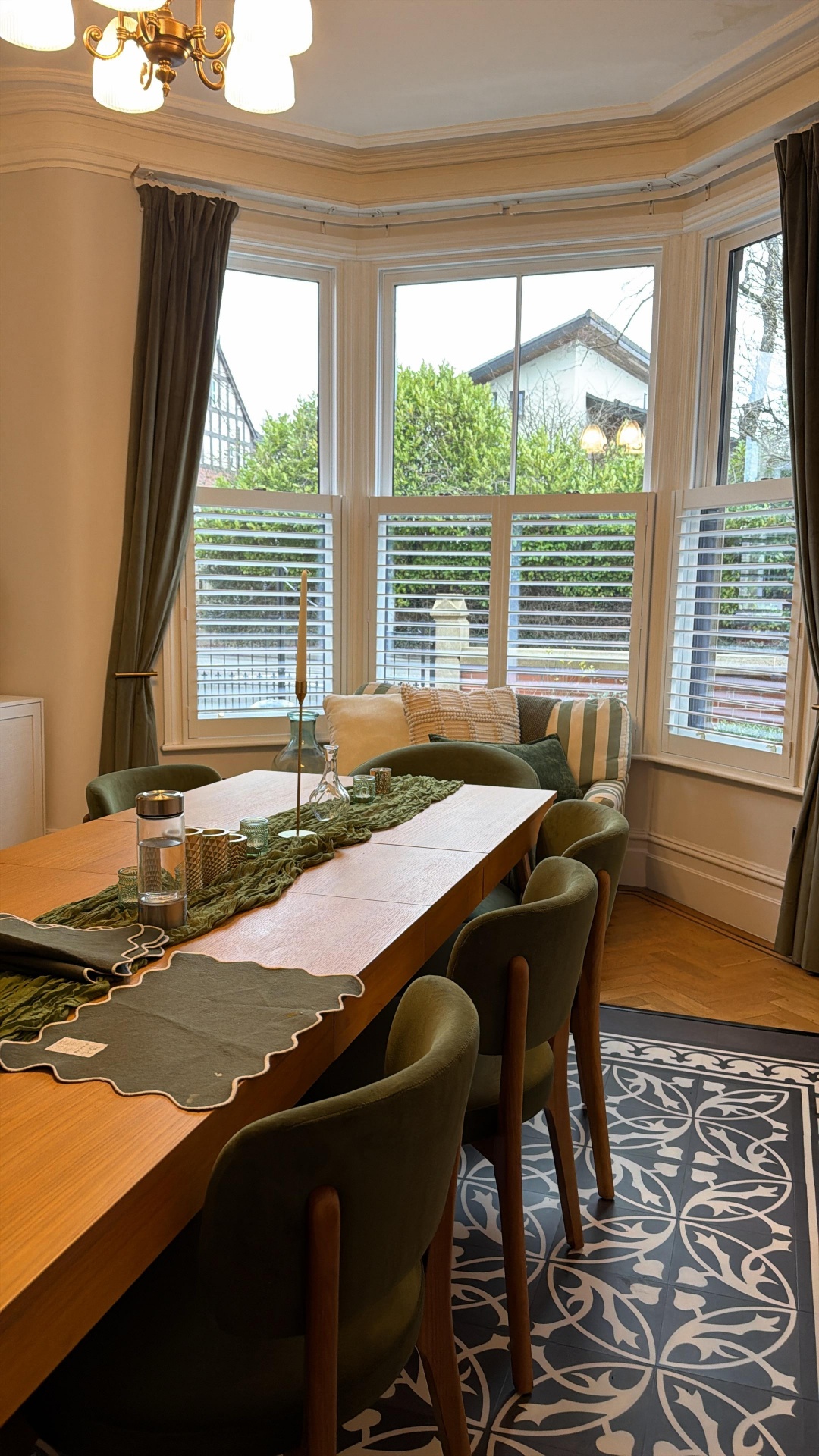 White café-style plantation shutters in a bay window dining room