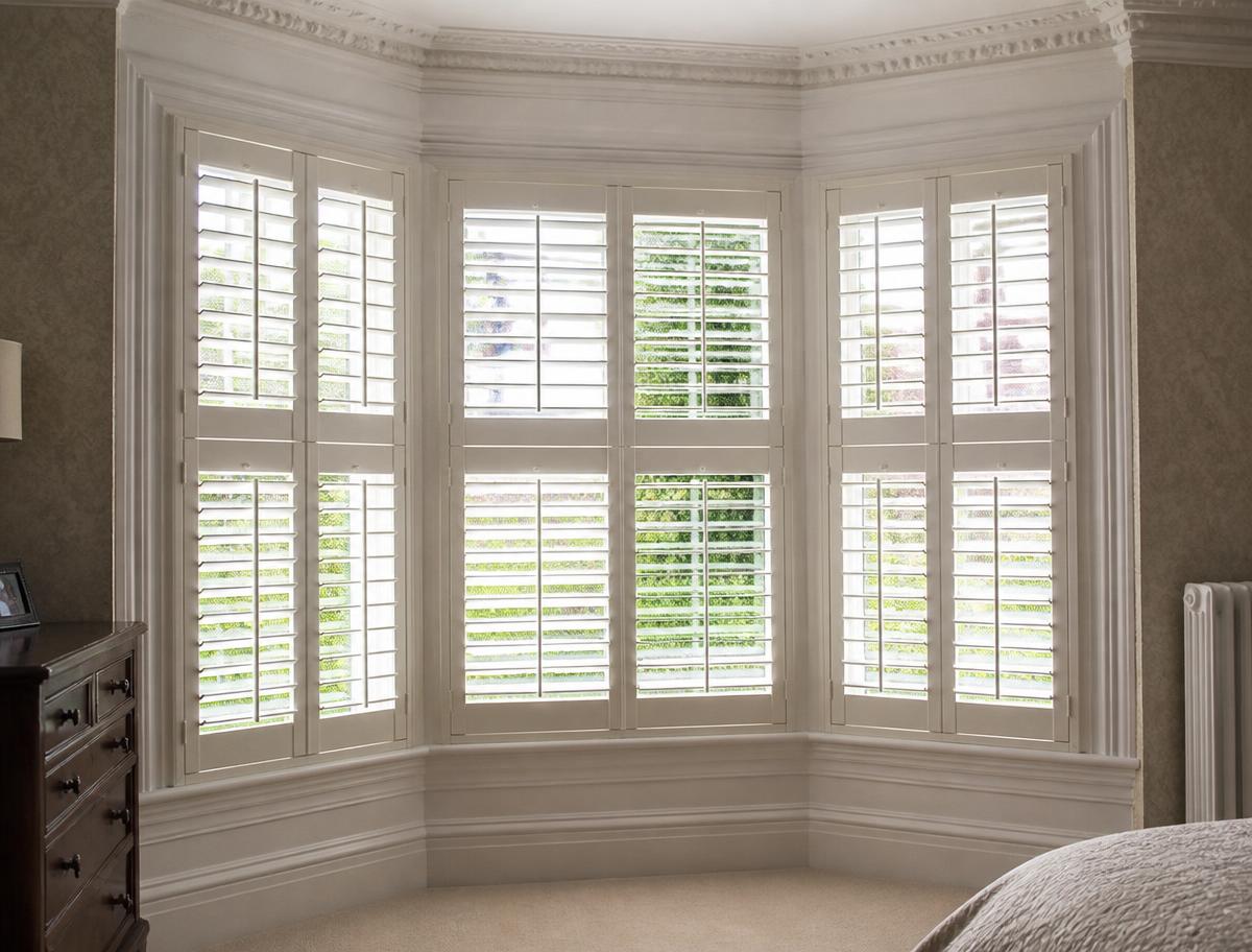 Painted hardwood shutters fitted to a Victorian bay window