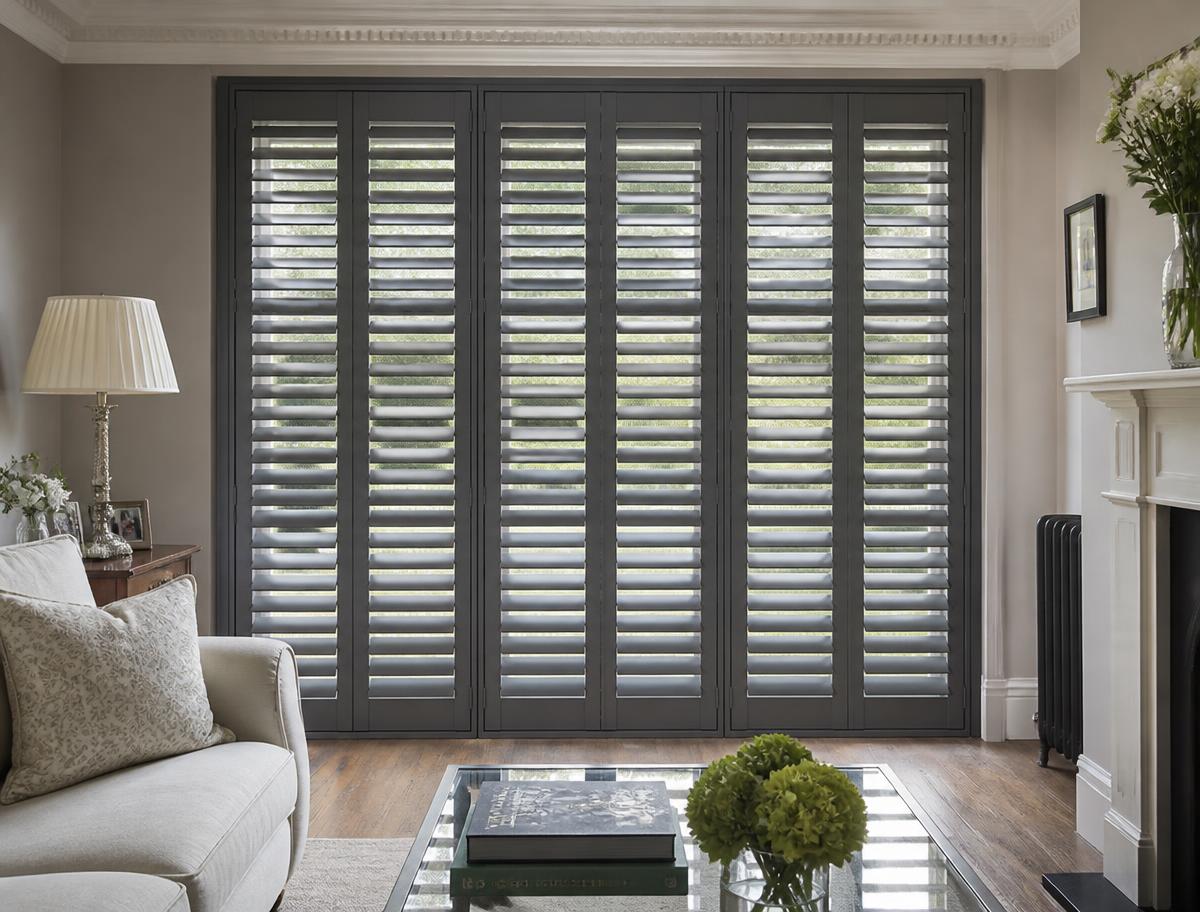 Full-height grey painted hardwood shutters in a living room